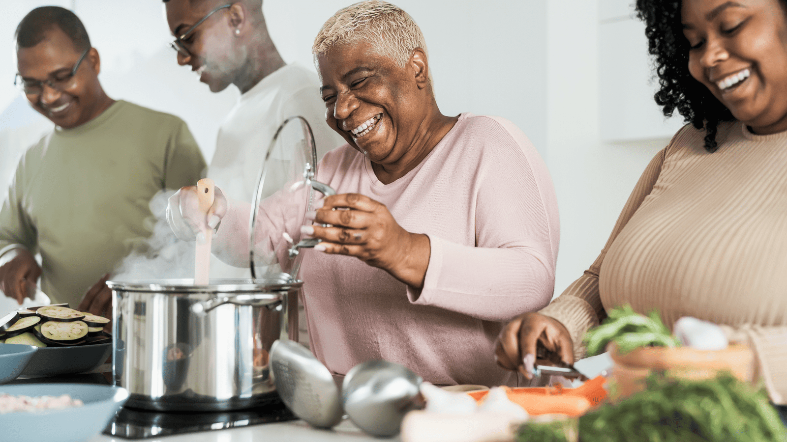 Black family smiling and laughing while preparing a holiday meal, finding connection and relief from family stress