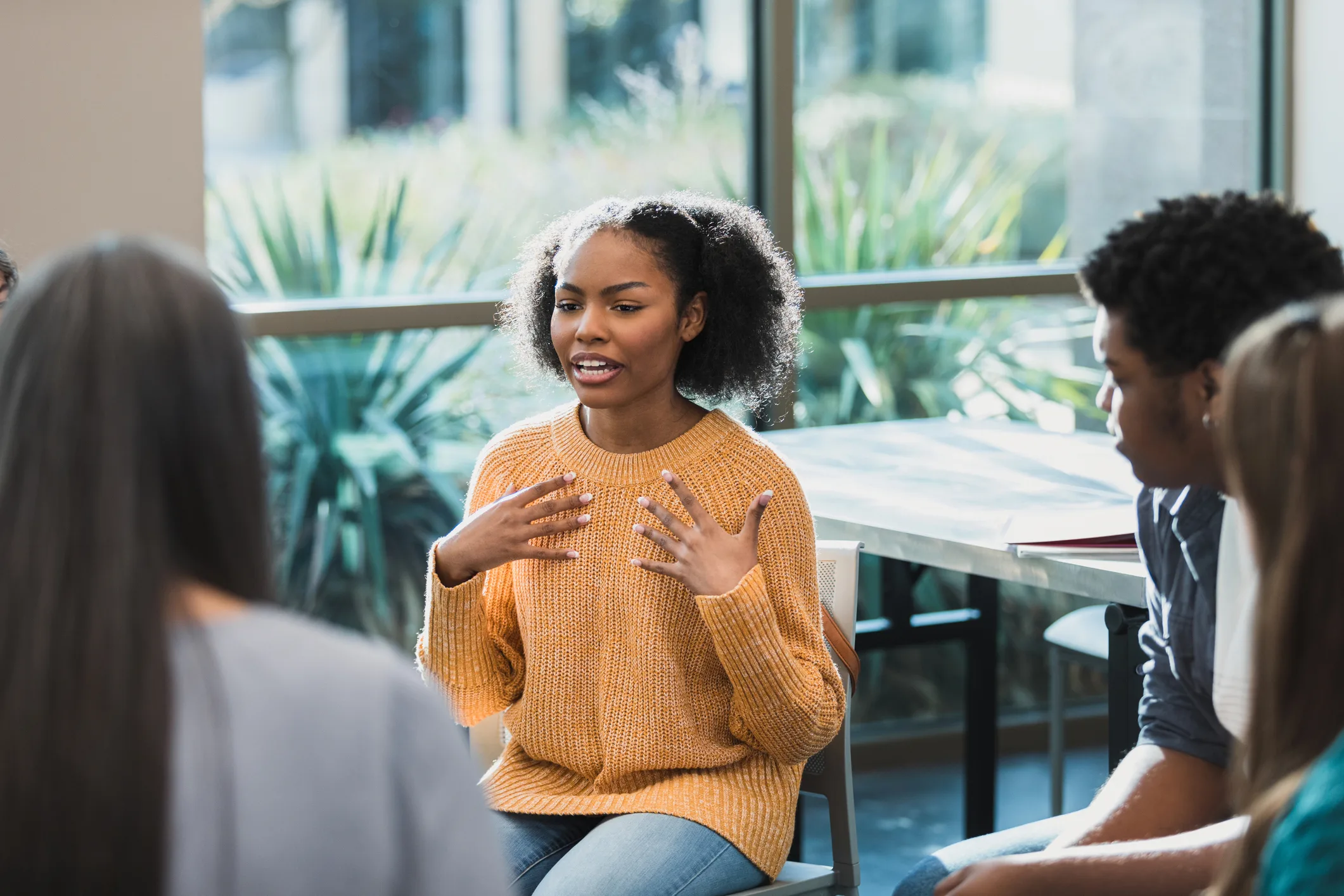 Black woman talks about emotions during therapy session in Atlanta, GA During a group therapy session in Atlanta, GA, a Black woman in yellow sweater discusses her emotions.