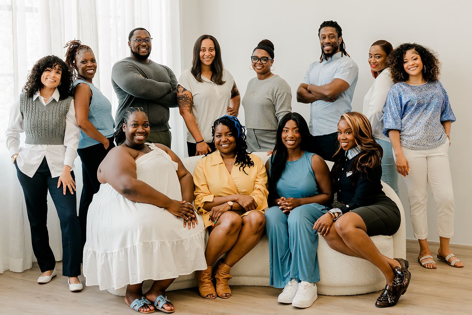 Simplicity Psychotherapy, LLC Eight Black Therapists wearing blue and white posing for photo in natural light. Representing Simplicity Psychotherapy group practice for Black men and women