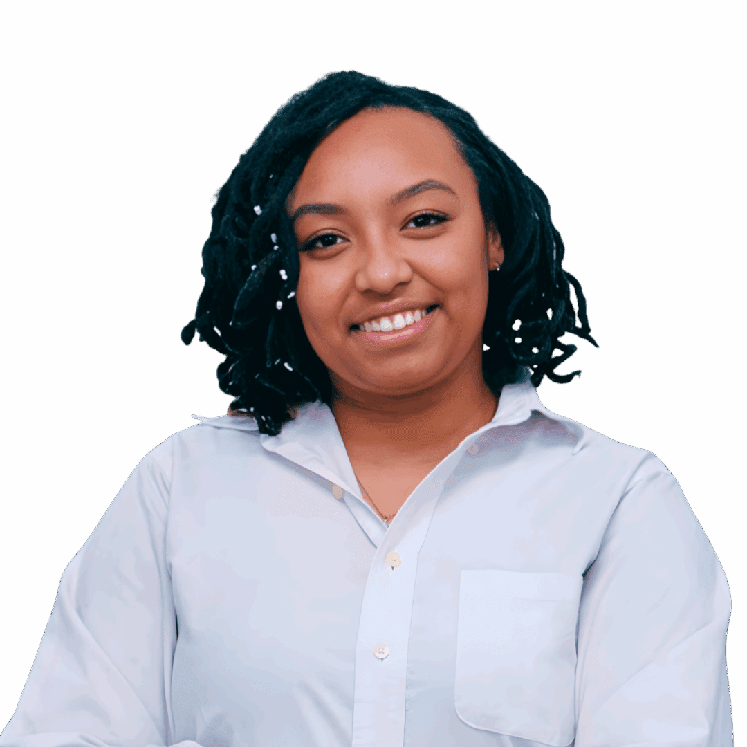 Smiling Black female therapist wearing a light blue button-down shirt and jeans, standing confidently with arms crossed, representing therapy for anxiety, identity concerns, and trauma in Georgia (30080, 30339, 30067, 30213).