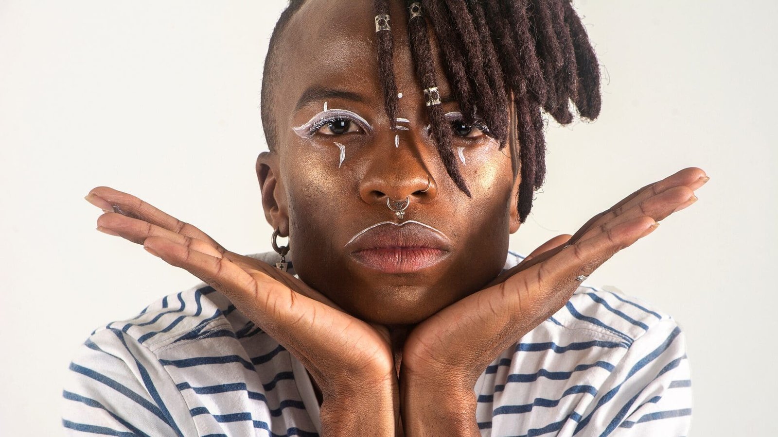 Adult with bold facial expression and creative makeup looking directly at the camera, representing LGBTQ therapy and queer affirming counseling in Georgia serving Atlanta 30307 and Savannah 31401.